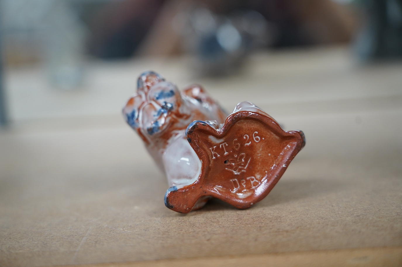 An unusual early Goebel tin glazed terracotta grotesque dog, in the style of Ida Meisinger, impressed no. KT.626., 10.5cm. Condition - good